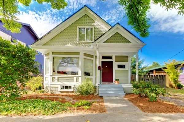 Exterior of charming, green single-family home with red door typical of Falls Church, Virginia