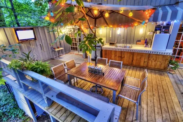 A kitchen, bar, and dining area on a deck with lights in Alexandria, Virginia
